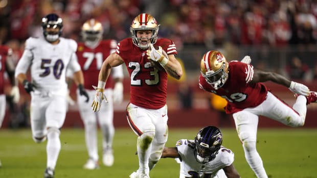 Dec 25, 2023; Santa Clara, California, USA; San Francisco 49ers running back Christian McCaffrey (23) runs the ball pressured by Baltimore Ravens cornerback Brandon Stephens (21) in the second quarter at Levi's Stadium. Mandatory Credit: Cary Edmondson-USA TODAY Sports  